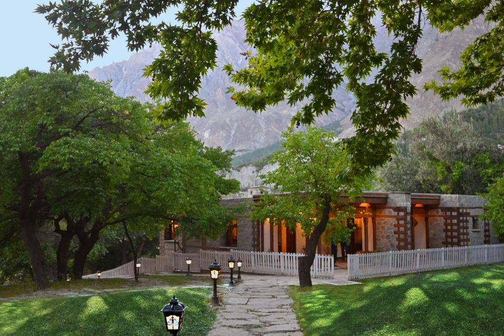 una casa con montañas en el fondo y jardín en SERENA ALTIT FORT RESIDENCE en Hunza