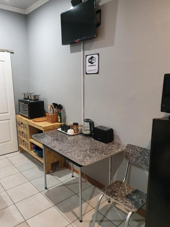 a kitchen with a counter and a table and chairs at Delikaat Bed & Coffee in Prieska