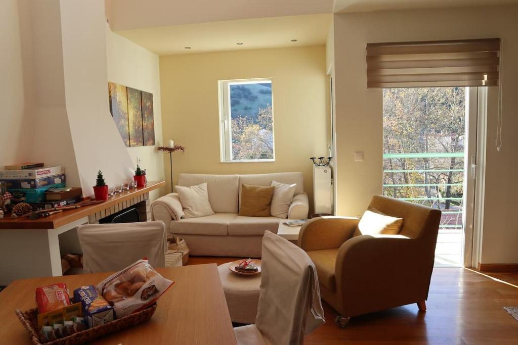 een woonkamer met een bank en een tafel bij Dream Mountain House in Kalavrita