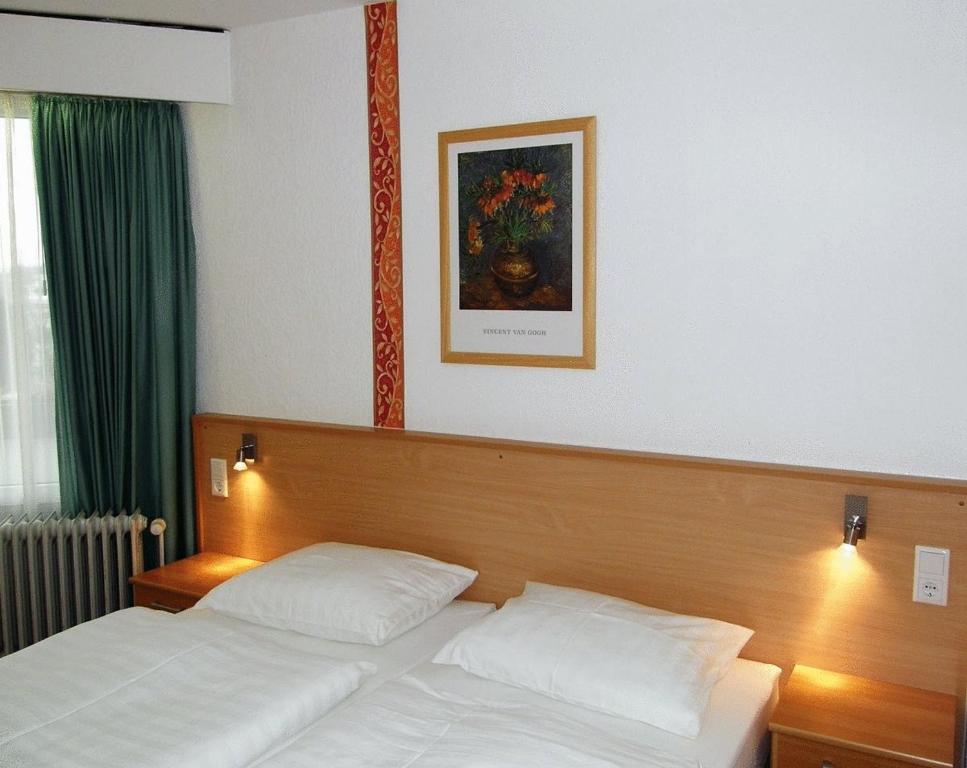 Hotel Deisterblick في باد نيندورف: غرفة نوم بسرير وصورة على الحائط