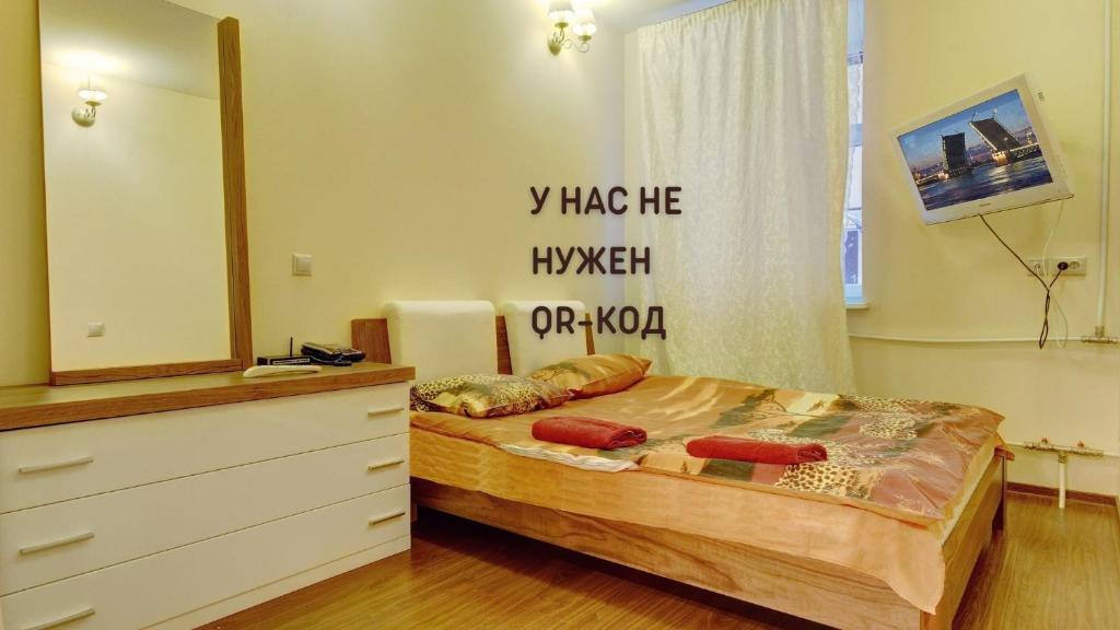 a bedroom with a bed with a dresser and a mirror at STN Apartments on Rubinsteina Street in Saint Petersburg