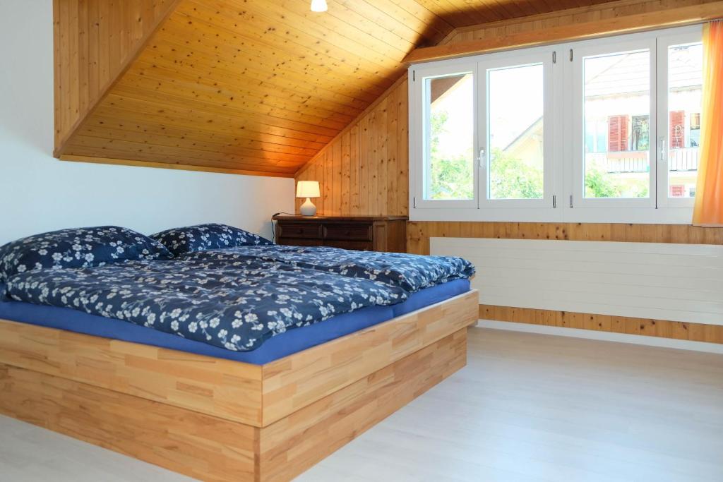 Bett in einem Zimmer mit Holzdecke in der Unterkunft Hauswurz in Thun
