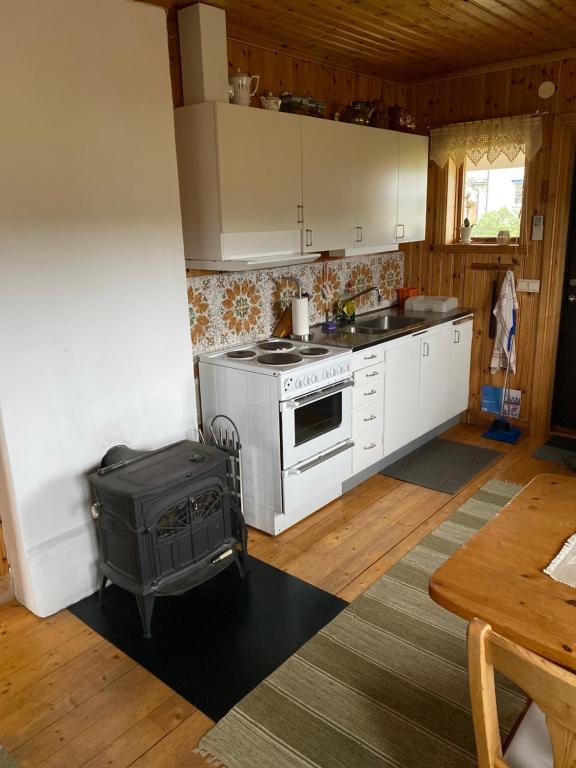 a kitchen with a white stove top oven next to a table at Backen in Torsby