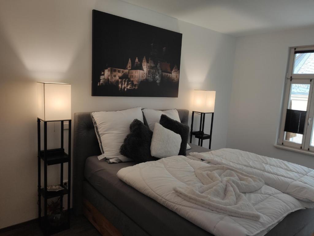 - une chambre dotée d'un grand lit avec des draps et des oreillers blancs dans l'établissement Exklusive Ferienwohnung im Einzeldenkmal, à Quedlinbourg