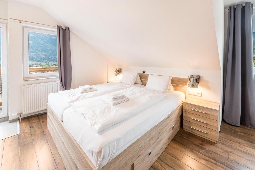 een groot wit bed in een kamer met een groot raam bij Mentenwirt Suite in Sankt Martin