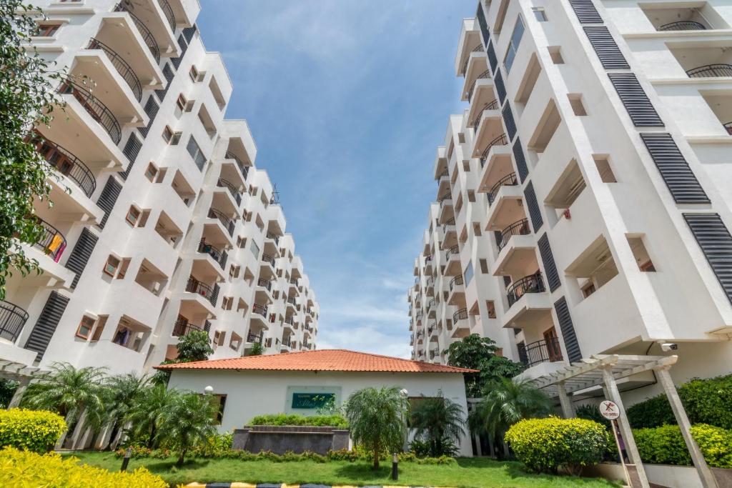 una vista di due grandi condomini con palme di Guesture Serviced Residences, Alta Vista a Bangalore