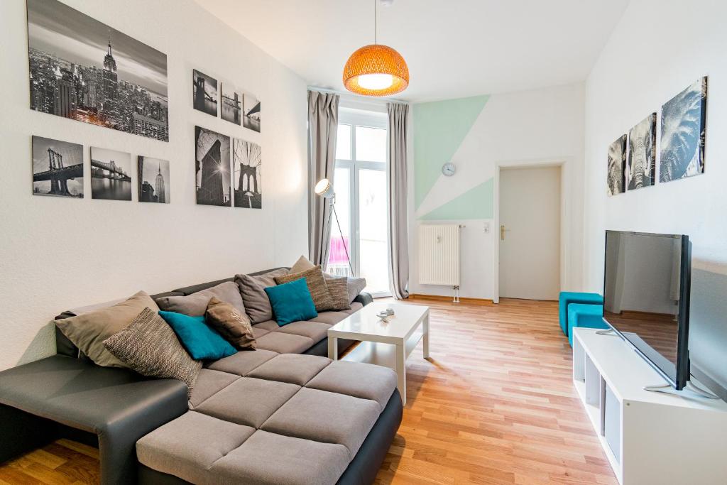 een woonkamer met een bank en een tv bij Helle Wohnung mit Balkon in grünen Innenhof - W-LAN, 4 Schlafplätze in Maagdenburg