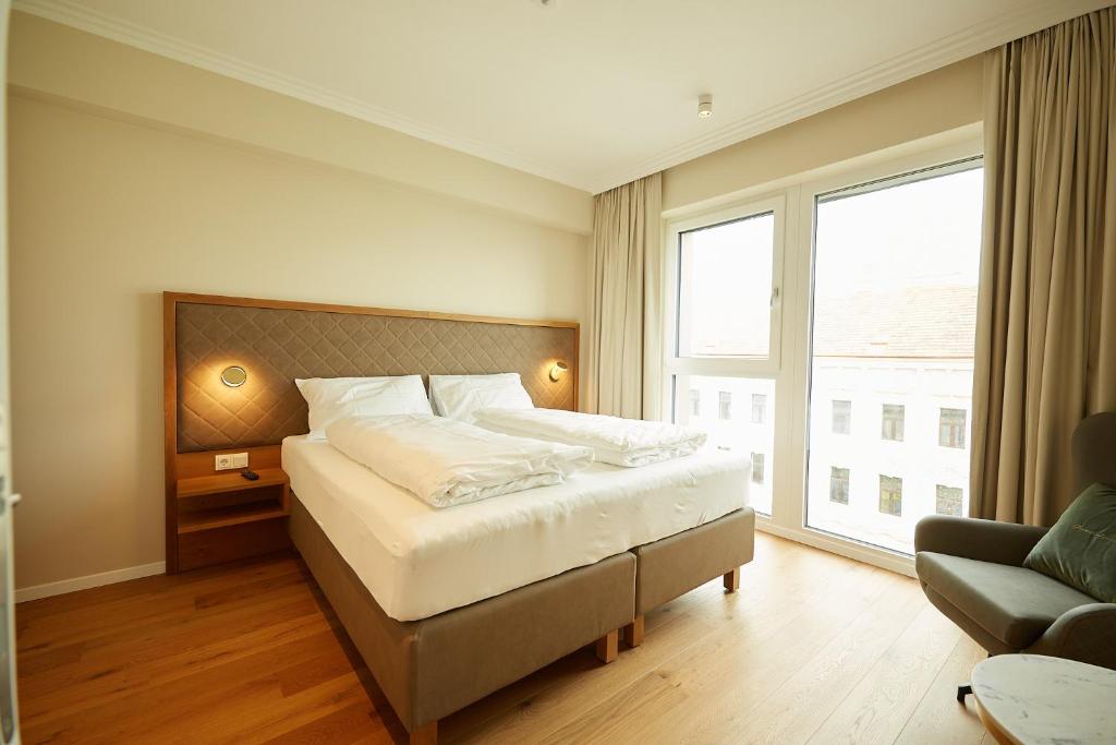 a bedroom with a bed and a large window at Green Leisure Apartments Schweglerstrasse in Vienna