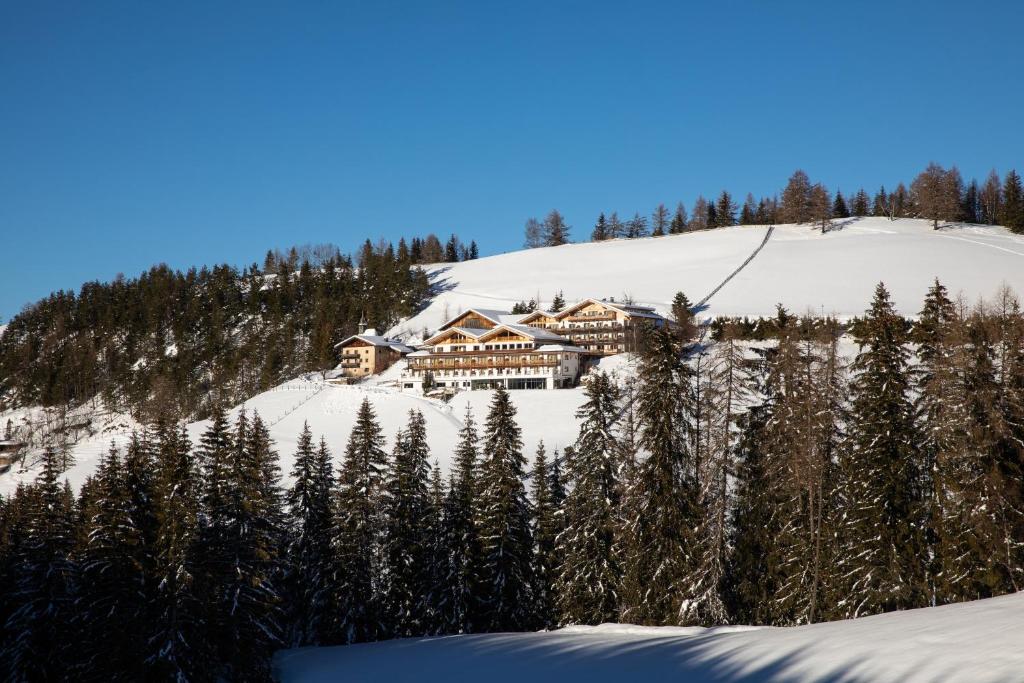a house on top of a snow covered mountain at Kräuterhotel Zischghof in Obereggen