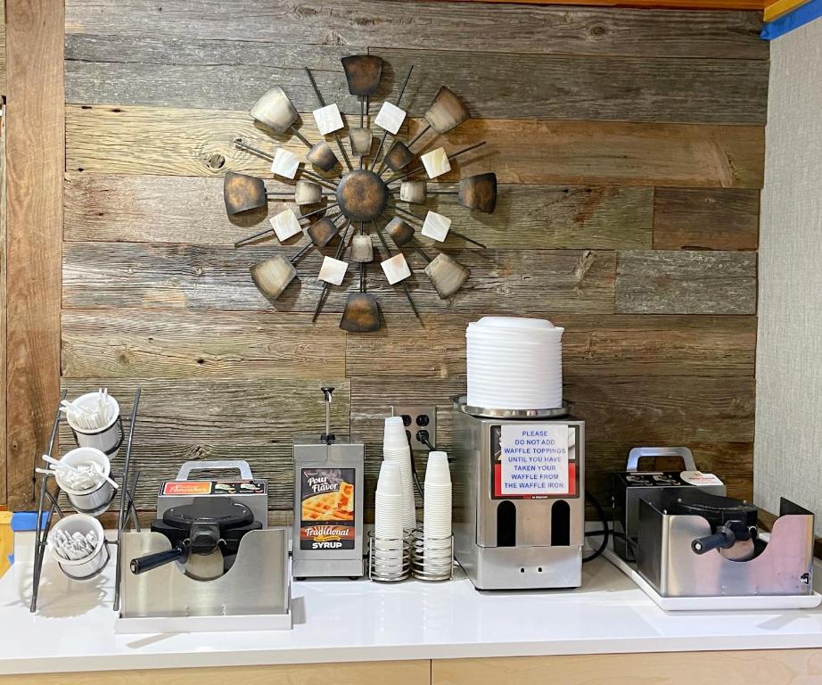 a kitchen counter with appliances on a table with a wooden wall at Baymont by Wyndham Gatlinburg On The River in Gatlinburg