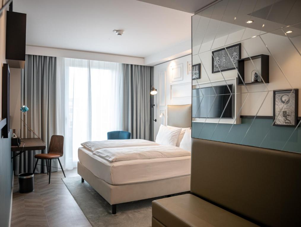 a hotel room with a bed and a desk at Hotel Indigo Dresden - Wettiner Platz by IHG in Dresden