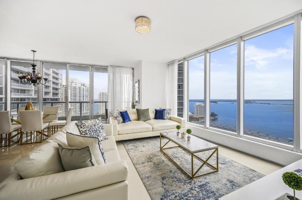 a living room with white furniture and large windows at Breathtaking Ocean View Unit Icon Brickell W in Miami