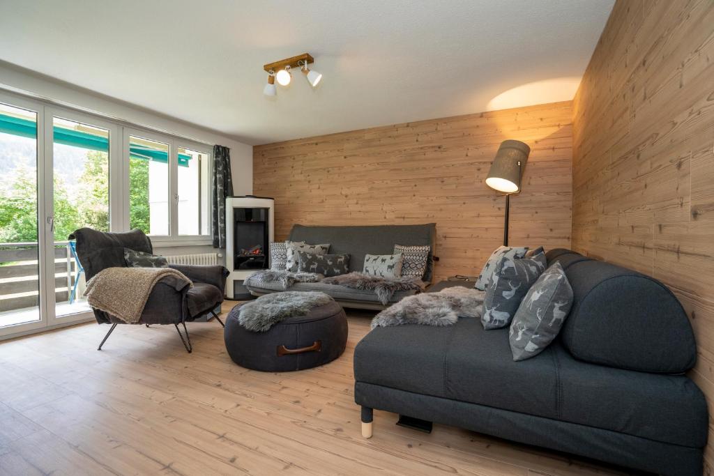 ein Wohnzimmer mit einem Sofa und einem Stuhl in der Unterkunft AAA Chalet, newly renovated with Sauna and Mountain view Allegra RoJo in Scuol