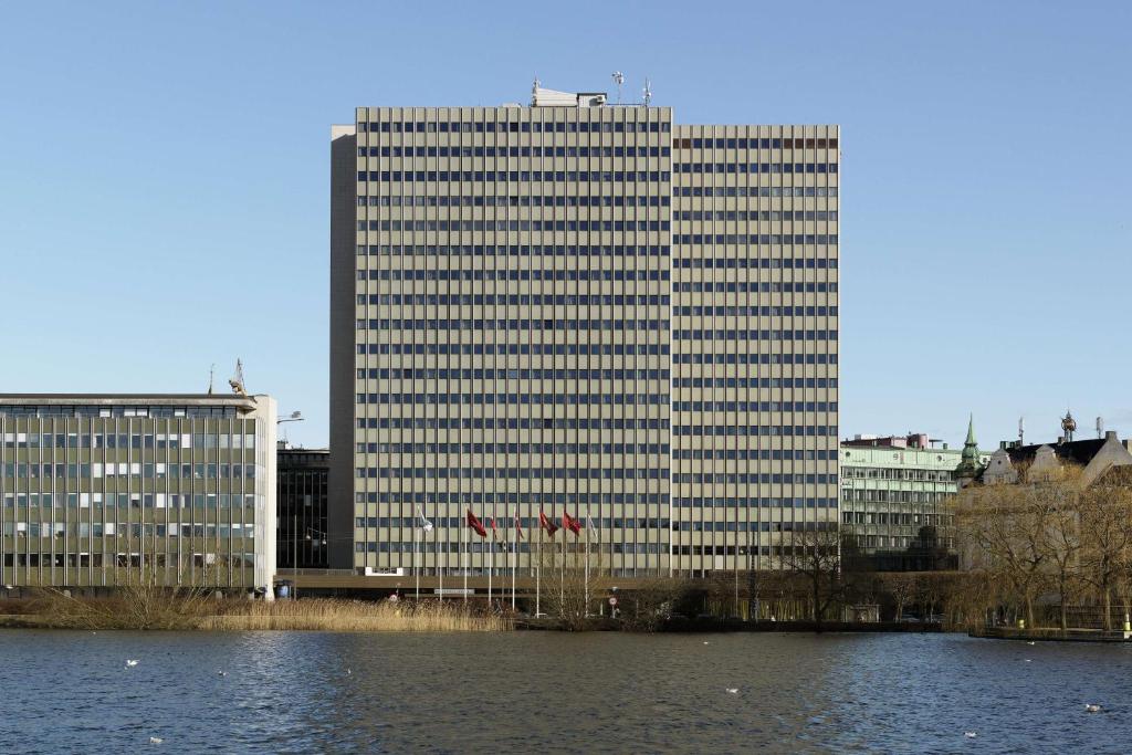 un edificio alto junto a un cuerpo de agua en Scandic Copenhagen, en Copenhague