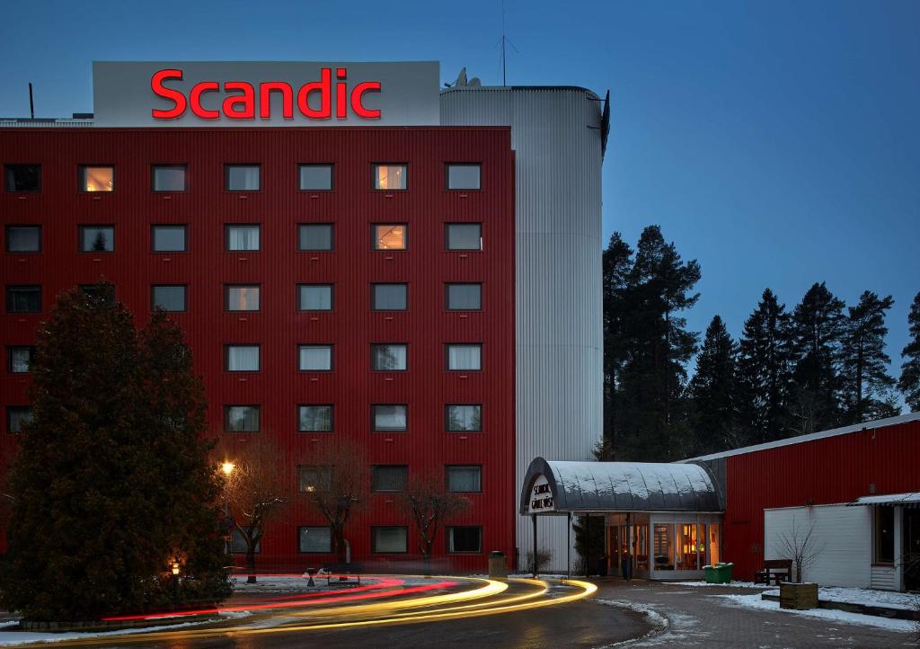 um edifício vermelho com uma placa de hotel de areia em Scandic Gävle Väst em Gävle