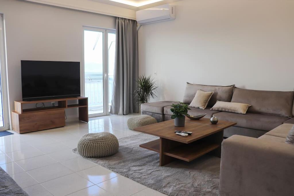 a living room with a couch and a flat screen tv at Superior Double Room with Stunning Sea View. DT in Patra
