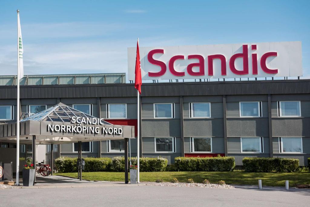 un edificio con un pilastro di sabbia e una bandiera di fronte di Scandic Norrköping Nord a Norrköping