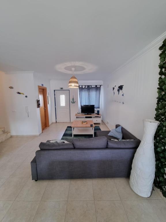 a living room with a couch and a table at Be Baleal Surfhouse in Baleal