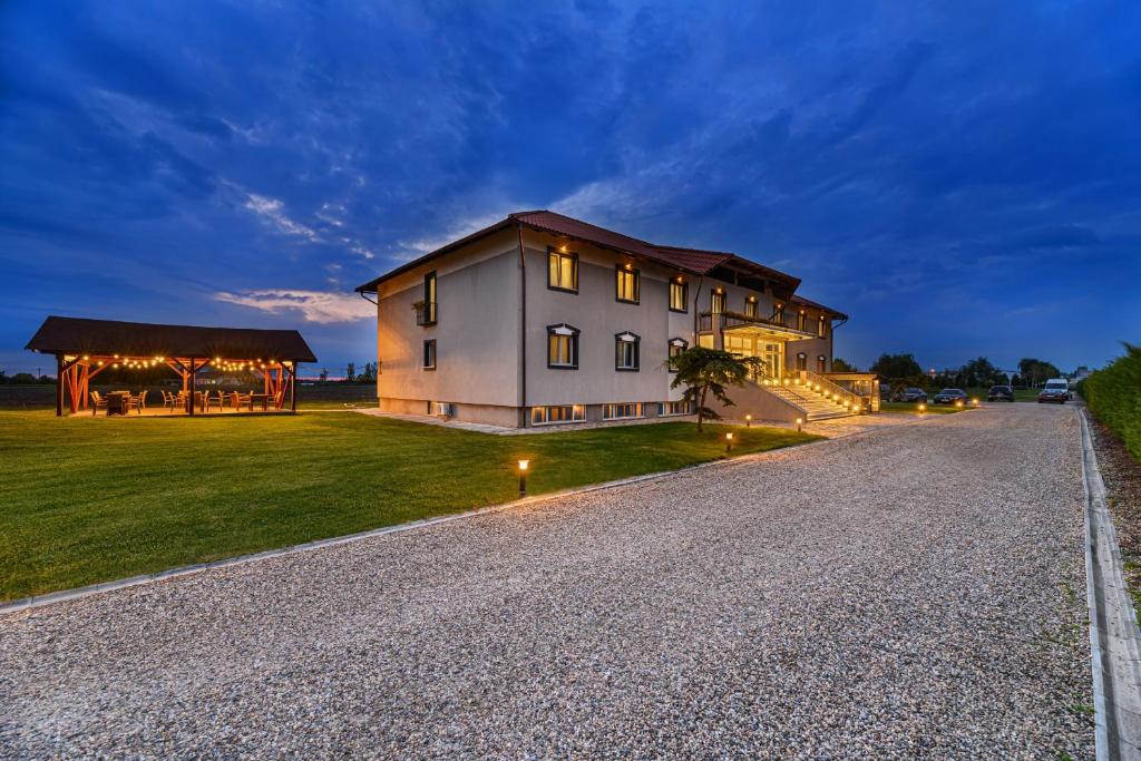 a large house on a grassy field at night at Stejarii Resort in Ineu