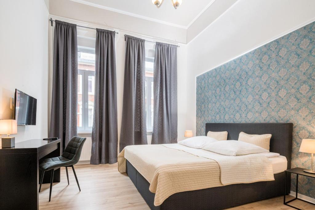 a bedroom with a bed and a desk and a window at Hotel Aurora in Wiesbaden