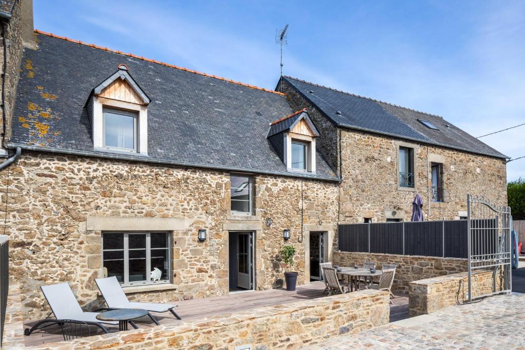 a stone house with a patio in front of it at LA PILOTINE - maison 2 chambres in Saint-Coulomb