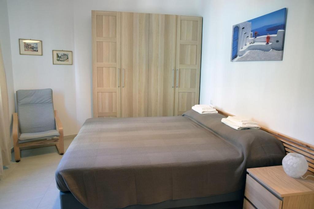 a bedroom with a large bed and a chair at Sunrise Apartment in Santa Margherita Ligure