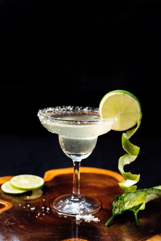 a martini glass with a slice of lime on a table at Qualia Resort Phu Quoc in Phú Quốc