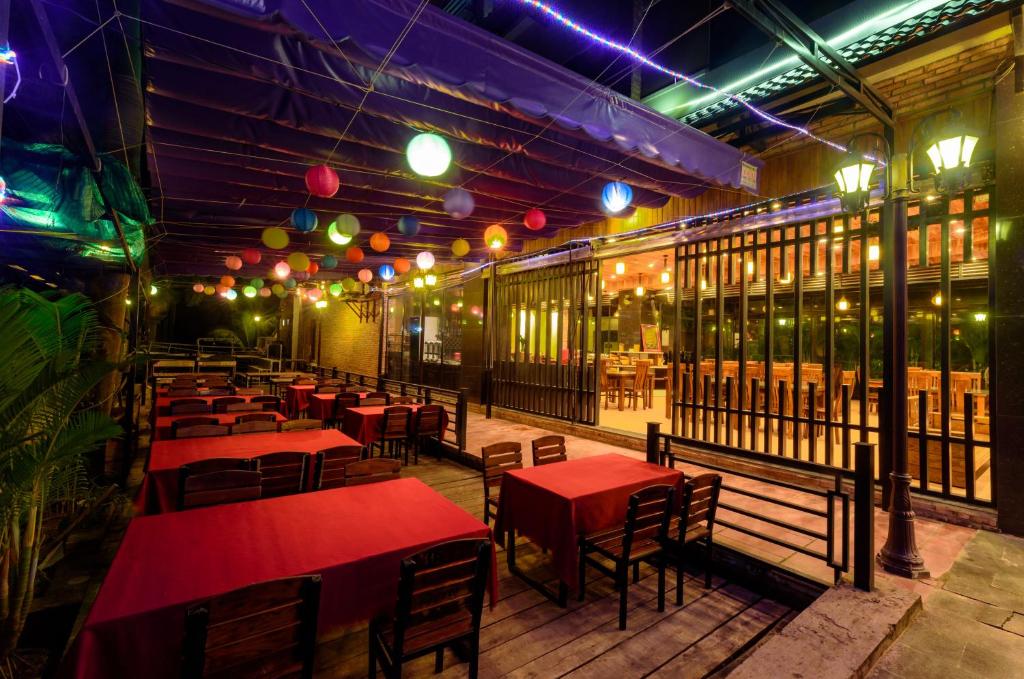 a restaurant with red tables and chairs and lights at Qualia Resort Phu Quoc in Phú Quốc