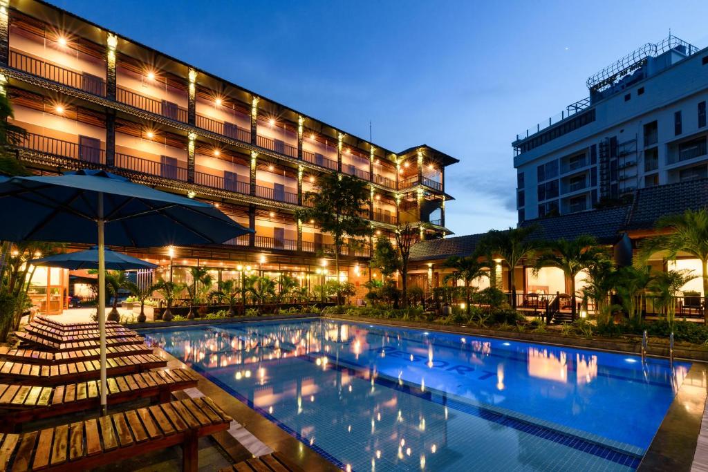 a hotel with a swimming pool in front of a building at Qualia Resort Phu Quoc in Phú Quốc