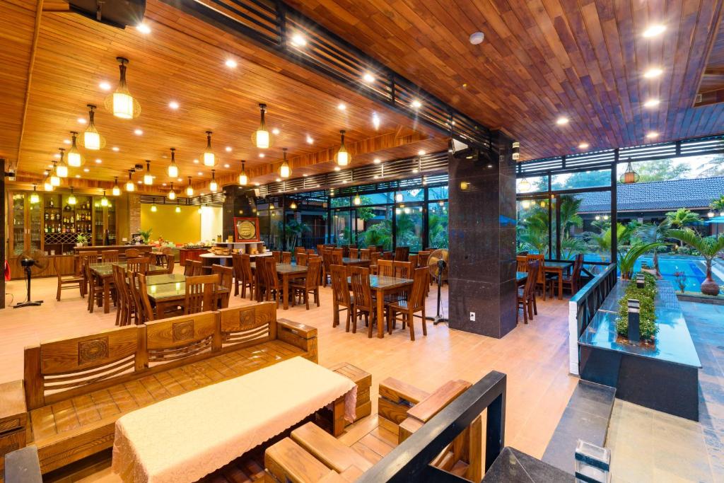 a restaurant with wooden tables and chairs and a cafeteria at Qualia Resort Phu Quoc in Phú Quốc