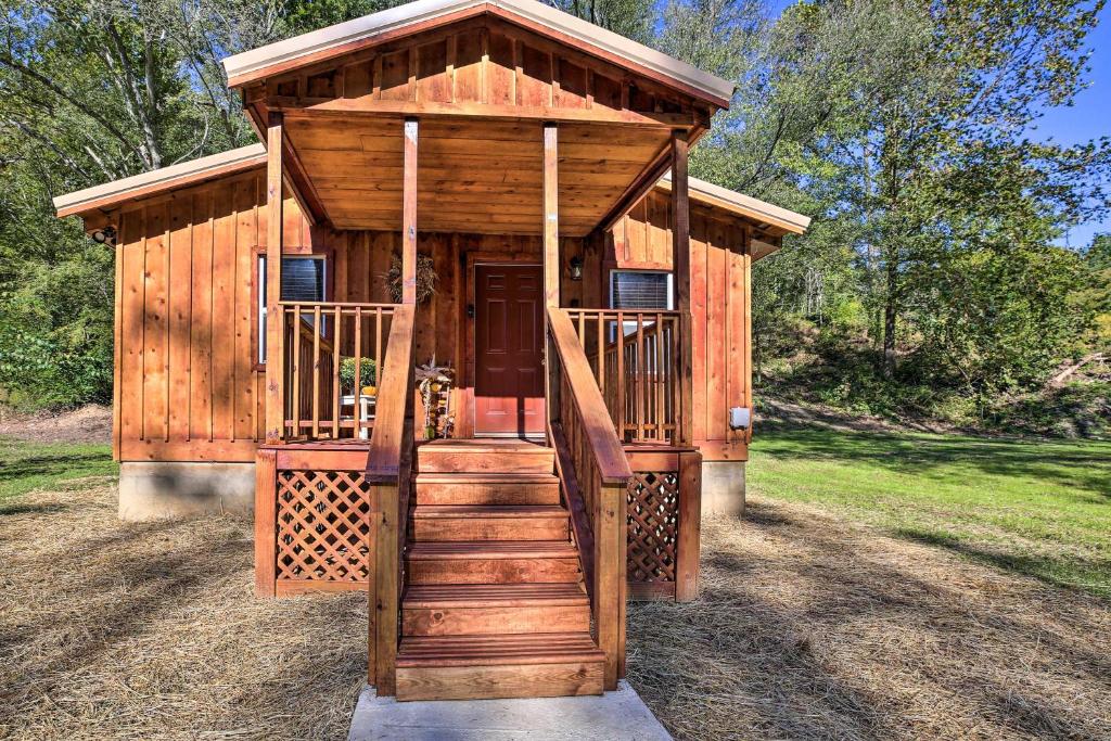 a wooden cabin with a staircase leading up to it at Silver Creek Cabin with Hiking, Less Than 1 Mi to Town! in Beattyville
