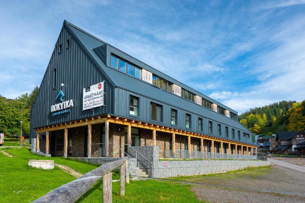 a large black building on the side of a road at Apartmány Rokytka Snowhouse in Rokytnice nad Jizerou