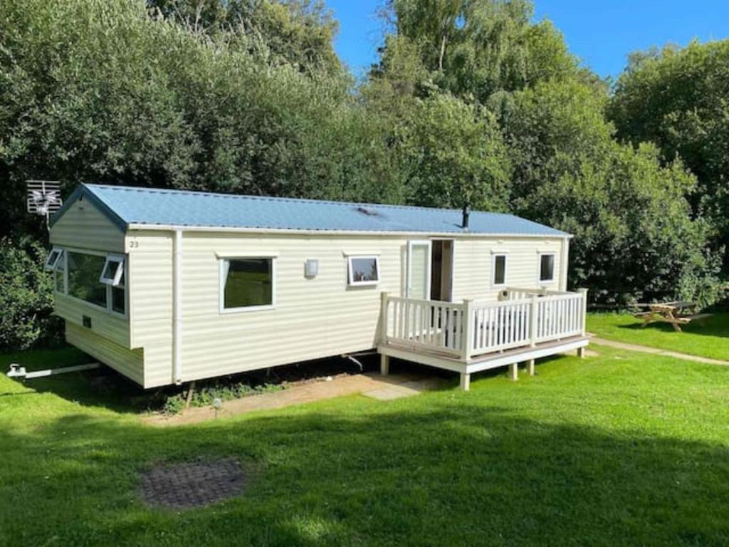 a white tiny house with a porch in a yard at Jubilee Lower Hyde Isle of Wight - Kingsgate 23 in Shanklin