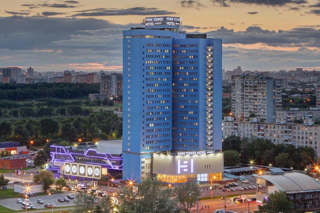 wysoki niebieski budynek z znakiem na górze w obiekcie Park Tower w Moskwie