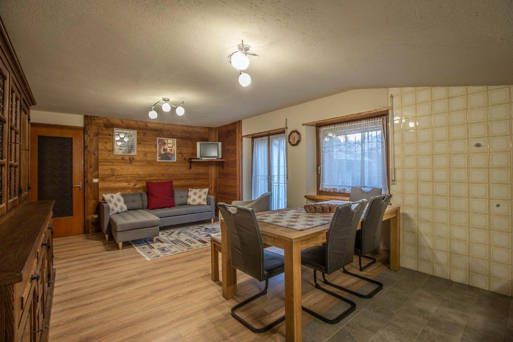 a living room with a table and chairs and a couch at L'Atelier du Temps - HERBETET Appartement in Cogne