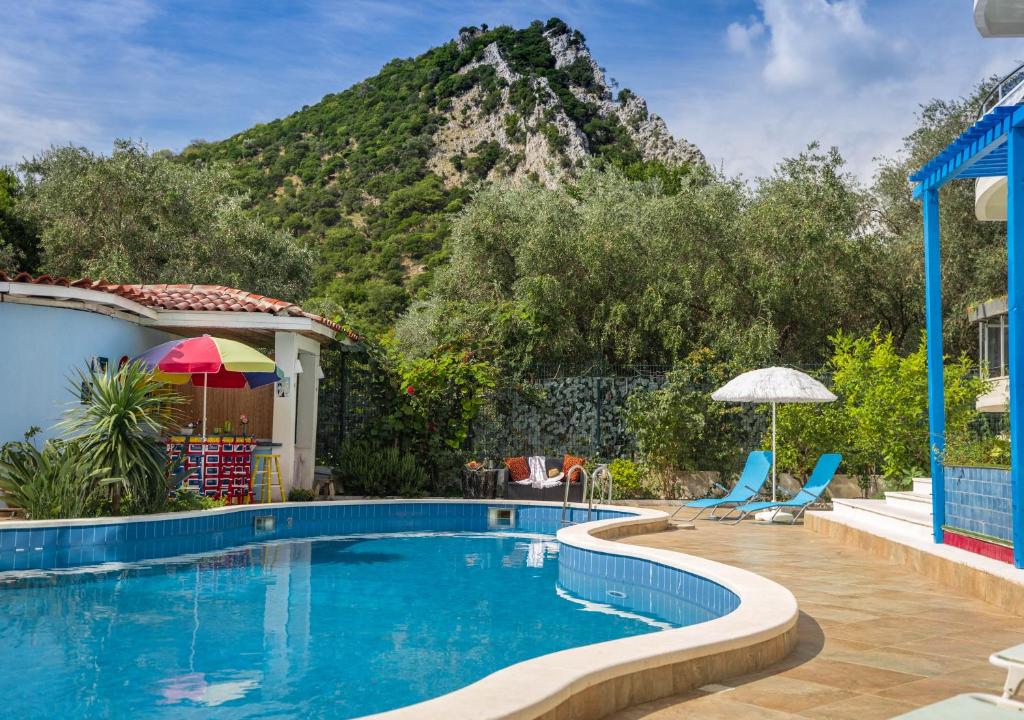 een zwembad met een berg op de achtergrond bij Villa Aurora in Petrovac na Moru