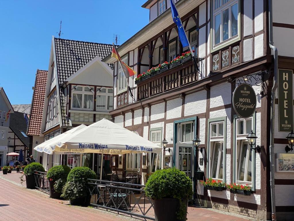 um edifício com um guarda-chuva branco em frente em Hotel Hagspihl em Quakenbrück