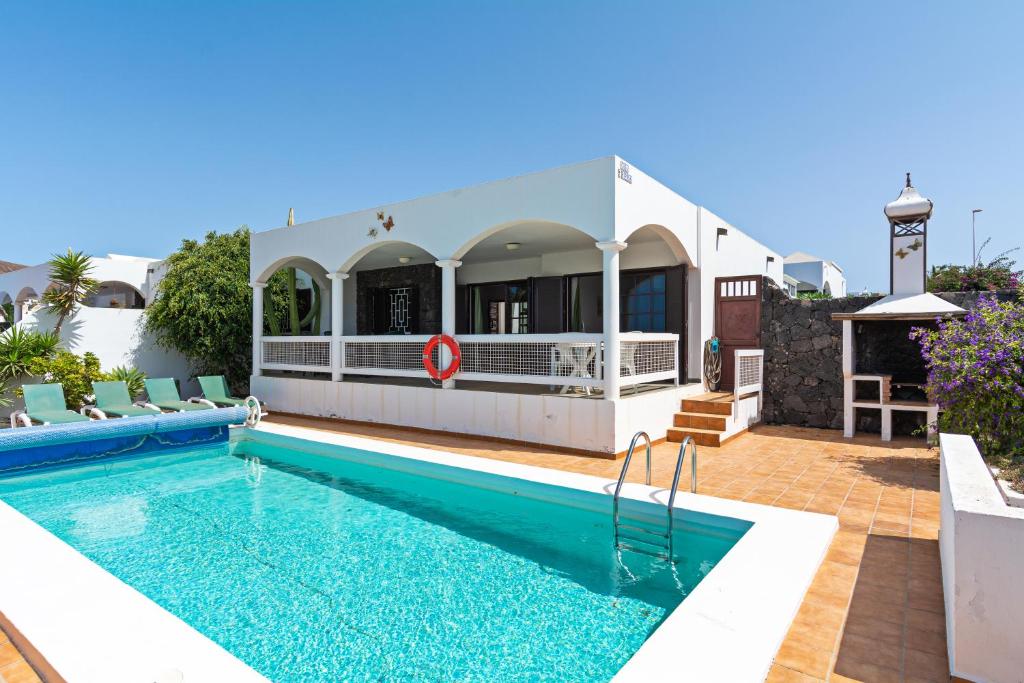 eine Villa mit Swimmingpool und ein Haus in der Unterkunft Villa Mariposa in Playa Blanca
