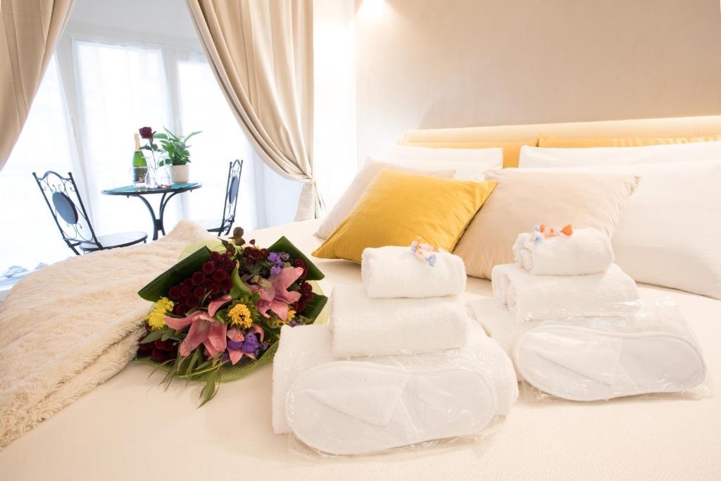 a white bed with towels and flowers on it at Chroma Italy - Chroma Octho in Rome