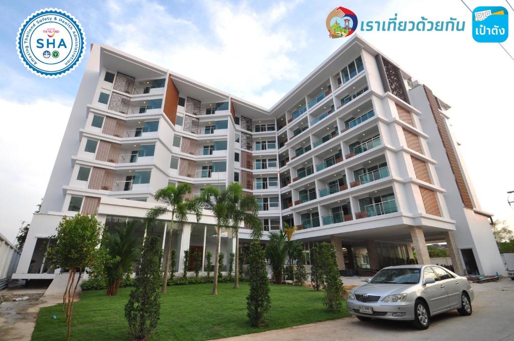 een groot appartementencomplex met een auto voor de deur bij Vareena palace hotel in Noord Pattaya