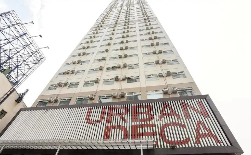 a tall building with a sign in front of it at Eimy's Place at Urban Deca Tower by RedDoorz in Manila