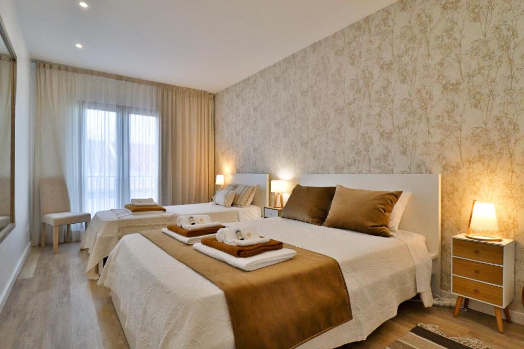 um quarto com 2 camas e uma janela em Janela Mar VIP em Ponta Delgada