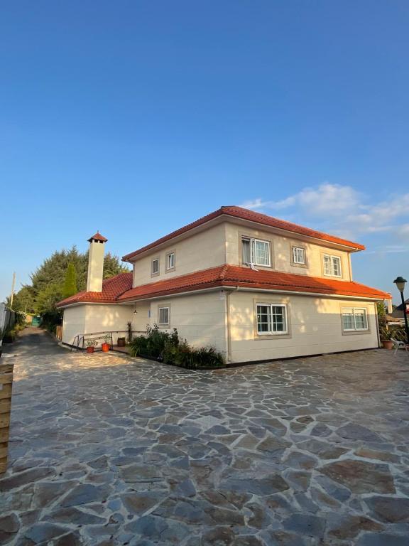 a large white house with a red roof at Mar De Frisia in O Pino 