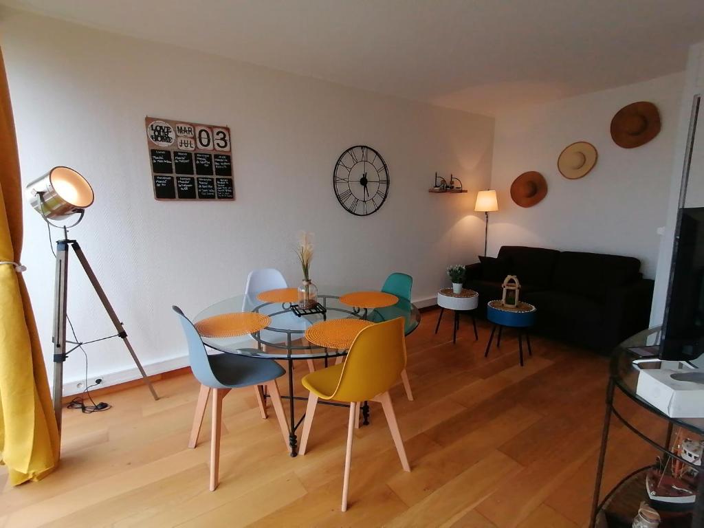 een woonkamer met een tafel en stoelen bij Ô Pied Marin in Le Tréport