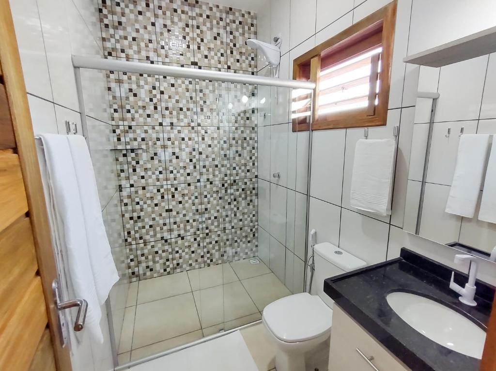 uma casa de banho com um chuveiro, um WC e um lavatório. em Pousada Brisas em Jijoca de Jericoacoara