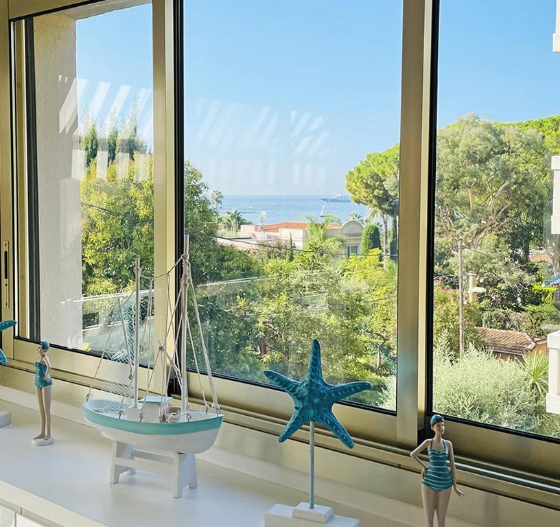 una ventana con dos estatuillas y una estrella de mar en una habitación en SPLENDIDE 3 PIECES VUE MER, en Antibes