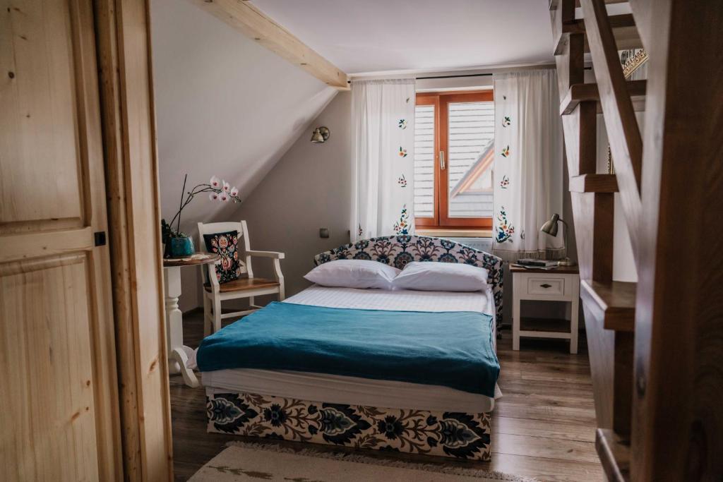 a small bedroom with a bed and a window at Apartament nad Potokiem in Witów