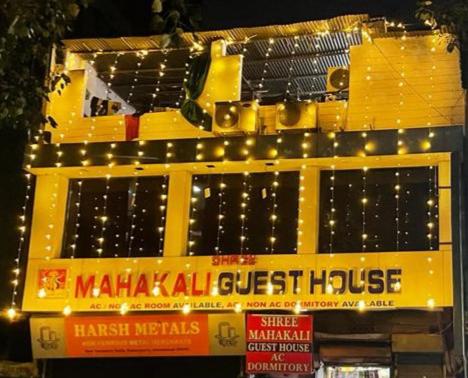 a yellow building with lights on top of it at Shree Mahakali Guest House & Dormitory in Ahmedabad