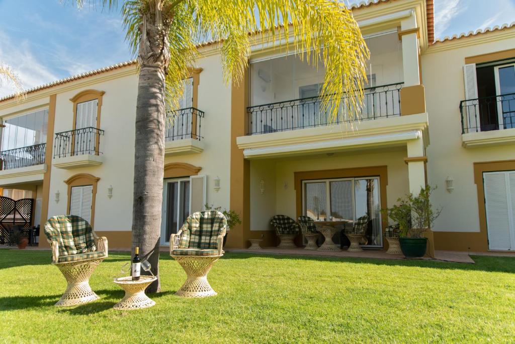 une grande maison avec un palmier dans la cour dans l'établissement Carvoeiro, 2BR Pestana Gramacho Golf Apartment, à Estômbar