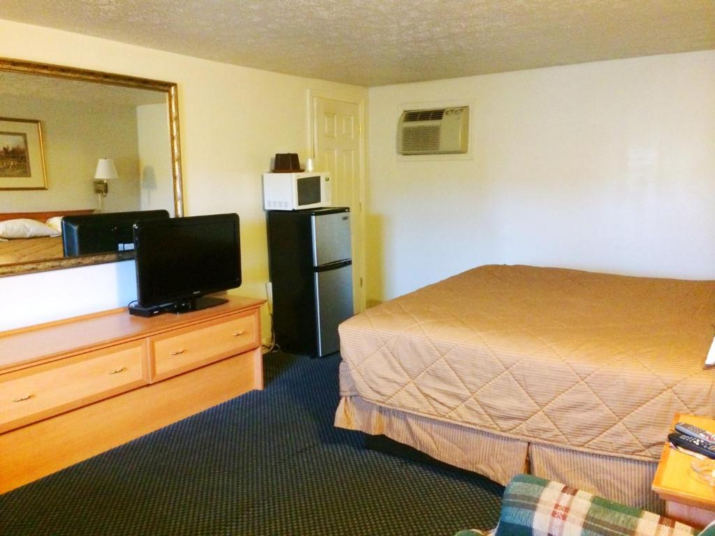 um quarto de hotel com uma cama e uma televisão em Motel Edgewood em Edgewood